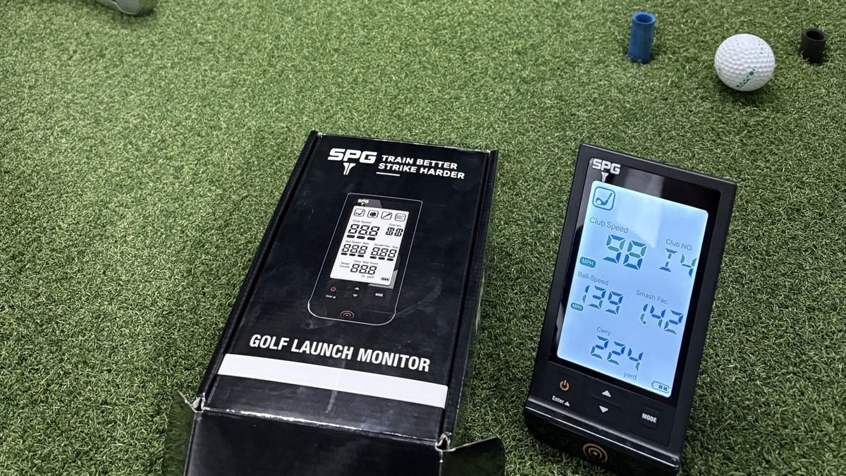 SPG Golf Launch Monitor and its box on a range mat beside a golf ball